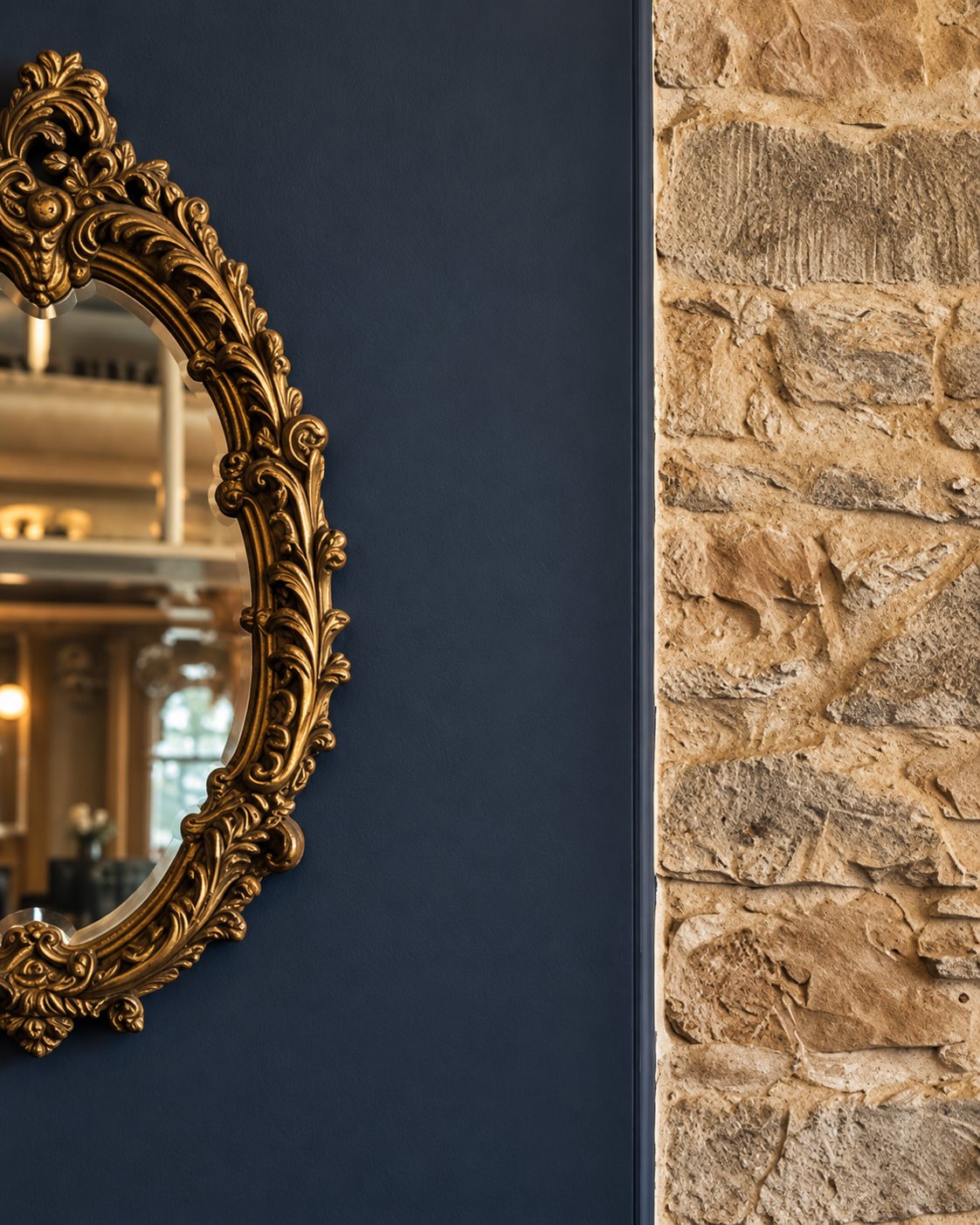 Ornate gold mirror and exposed stone wall inside Milne’s in Dunoon