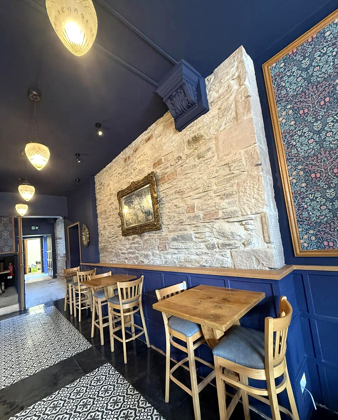 Stone wall and blue seating along the interior of Milne’s in Dunoon